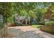View of the blue house from the long driveway, surrounded by green trees at 1592 Braeburn Se Dr, Atlanta, GA 30316
