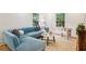 Bright living room with a blue sofa, white walls and hardwood floors at 1592 Braeburn Se Dr, Atlanta, GA 30316