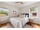 A bright bedroom with hardwood floors, two windows, ceiling fan and a comfortable bed with pillows at 2855 Monticello Pl, Decatur, GA 30030
