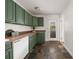A functional kitchen featuring green cabinetry, wood countertops, slate flooring, and modern appliances at 2855 Monticello Pl, Decatur, GA 30030