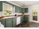 Well-lit kitchen featuring green cabinets, a farmhouse sink, and slate tile floors at 2855 Monticello Pl, Decatur, GA 30030