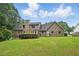 Expansive backyard featuring a lush green lawn, mature trees, and a covered patio at 2868 Wood Park Nw Trce, Kennesaw, GA 30152
