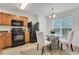Cozy kitchen with black appliances and wood cabinets next to a dining area with natural lighting at 3516 Waldrop Trl, Decatur, GA 30034