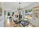Open dining area with a glass table, sleek chairs, modern chandelier and views of the kitchen at 102 Rockyford, Atlanta, GA 30317
