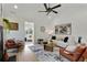 Bright living room features a modern ceiling fan, fireplace, leather chairs, and a view into the sunroom at 102 Rockyford, Atlanta, GA 30317