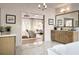 Elegant bathroom with a soaking tub, wooden cabinets, and marble flooring leading to bedroom at 2480 Bleckley Pl, Cumming, GA 30041