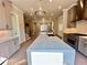 View of the open concept kitchen with stainless steel appliances, gray cabinets and large island with pendant lighting at 285 Briscoe Way # 2, Alpharetta, GA 30009