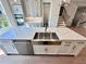 Modern kitchen island features stainless steel sink, dishwasher and white cabinets and drawers at 285 Briscoe Way # 2, Alpharetta, GA 30009