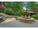 Relax in this backyard with stone hot tub, rock waterfall, and wooden deck, all surrounded by greenery at 4030 River Ridge Se, Marietta, GA 30067
