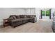 Spacious basement featuring light tile flooring, a plush sectional, and natural light from the large window at 4030 River Ridge Se, Marietta, GA 30067