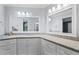Long bathroom vanity with white cabinets, granite countertop, and dual mirrors at 4030 River Ridge Se, Marietta, GA 30067