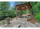 Enjoy grilling in the outdoor kitchen with gazebo, featuring a stone floor, wood ceiling, and leafy surroundings at 4030 River Ridge Se, Marietta, GA 30067