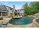 The backyard features a stone-trimmed pool with a waterfall next to an outdoor dining and lounge area at 4030 River Ridge Se, Marietta, GA 30067