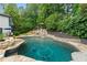 Beautiful backyard pool with stone accents, waterfall feature, and lush landscaping create a private oasis at 4030 River Ridge Se, Marietta, GA 30067