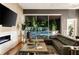 Open-concept living room with sleek fireplace, comfortable leather sectional, and a view of the outdoor pool area at 1242 Wild Creek Ne Trl, Atlanta, GA 30324