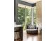 Inviting living area features a modern chair and a large window with views of the lush greenery at 1242 Wild Creek Ne Trl, Atlanta, GA 30324