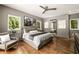 Bright main bedroom with hardwood floors, a ceiling fan, and windows overlooking lush scenery at 1242 Wild Creek Ne Trl, Atlanta, GA 30324