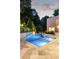 Stunning pool and spa featuring blue tile and beautiful stone work surrounded by lovely landscaping and hardscaping at 1242 Wild Creek Ne Trl, Atlanta, GA 30324