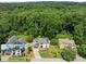 An aerial shot showing a home surrounded by mature trees and lush greenery at 130 Timber Oak Cv, Lawrenceville, GA 30043