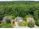 Aerial shot of a home with a well-manicured lawn surrounded by lush greenery and mature trees at 130 Timber Oak Cv, Lawrenceville, GA 30043