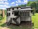 An exterior view of a home featuring a screened porch, exterior stairs, and mature trees at 130 Timber Oak Cv, Lawrenceville, GA 30043
