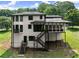 Backyard view of the house featuring stairs, large windows, and a covered porch at 130 Timber Oak Cv, Lawrenceville, GA 30043