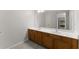 Bathroom vanity featuring double sinks, white countertop, and wood cabinetry, with a large mirror above at 130 Timber Oak Cv, Lawrenceville, GA 30043