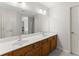 Bathroom featuring double sink vanity, white countertop, and wood cabinetry with two doors on either side at 130 Timber Oak Cv, Lawrenceville, GA 30043
