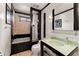 Bathroom with a glass countertop sink, built-in shelves, and tiled bathtub at 130 Timber Oak Cv, Lawrenceville, GA 30043