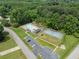 Overhead view of a community pool, tennis court, and parking area with trees surrounding the facilities at 130 Timber Oak Cv, Lawrenceville, GA 30043