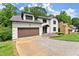 A front exterior view of a two-story home with a brick driveway and well-maintained lawn at 130 Timber Oak Cv, Lawrenceville, GA 30043