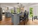 Kitchen bar with two barstools, hardwood floors, granite countertops and stainless steel appliances at 130 Timber Oak Cv, Lawrenceville, GA 30043