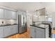 Kitchen with stainless appliances, gas cooktop on center island, gray cabinets and hardwood floors at 130 Timber Oak Cv, Lawrenceville, GA 30043