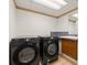 Laundry room featuring modern black washer and dryer set with sink and cabinetry at 130 Timber Oak Cv, Lawrenceville, GA 30043