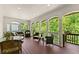 Covered porch with multiple seating areas and views of lush greenery at 130 Timber Oak Cv, Lawrenceville, GA 30043