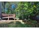 Backyard featuring a multi-tiered deck, lush lawn, and mature trees providing ample shade at 2066 Tidwell Trl, Stone Mountain, GA 30088