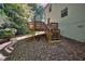 Backyard featuring a multi-tiered deck, lush lawn, and mature trees providing ample shade at 2066 Tidwell Trl, Stone Mountain, GA 30088
