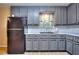 Updated kitchen features gray cabinets, black appliances, and granite countertops at 2066 Tidwell Trl, Stone Mountain, GA 30088