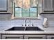 Close up of kitchen sink with gray cabinets and window at 2066 Tidwell Trl, Stone Mountain, GA 30088