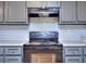 Black kitchen stove and oven with gray cabinets and white subway tile at 2066 Tidwell Trl, Stone Mountain, GA 30088