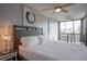 Bright bedroom featuring large windows, ceiling fan, stylish decor and a comfortable queen size bed at 215 Piedmont Ne Ave # 804, Atlanta, GA 30308