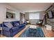 Cozy living room featuring a blue couch, wood floors, a mirror, and comfortable seating at 215 Piedmont Ne Ave # 804, Atlanta, GA 30308