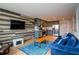 Open living area with a flat screen tv, wood feature wall, blue couch, and stainless steel kitchen at 215 Piedmont Ne Ave # 804, Atlanta, GA 30308