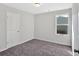 Bright bedroom featuring neutral walls, plush carpeting, and a window providing natural light at 3 Windsor Ct, Kingston, GA 30145