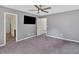 Neutral bedroom space leading to a bathroom, carpeted and well-lit with mounted TV at 3 Windsor Ct, Kingston, GA 30145