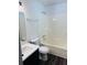 Bright bathroom featuring a white sink, toilet, and shower with dark wood flooring at 415 Dove Ln, Social Circle, GA 30025