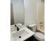 Bright bathroom featuring a white sink, toilet, and shower with dark wood flooring at 415 Dove Ln, Social Circle, GA 30025
