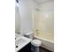 Bright bathroom featuring a white sink, toilet, and shower with dark wood flooring at 415 Dove Ln, Social Circle, GA 30025
