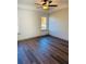 Bedroom with ceiling fan, tray ceiling, two windows, and hardwood floors at 415 Dove Ln, Social Circle, GA 30025