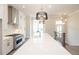 Open kitchen view featuring stainless steel stove and hood, along with a large island and modern pendant lighting at 530 Fisher Dr # 45, Alpharetta, GA 30009